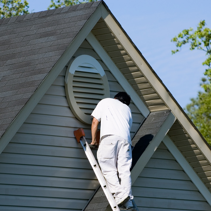 man painting the exterior of a home