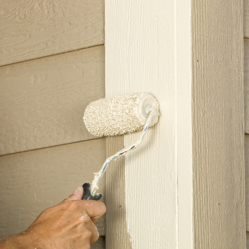 someone using a paint roller on a house