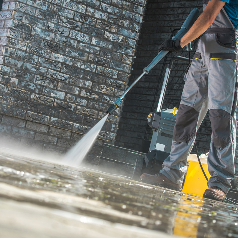 someone pressure washing a walkway