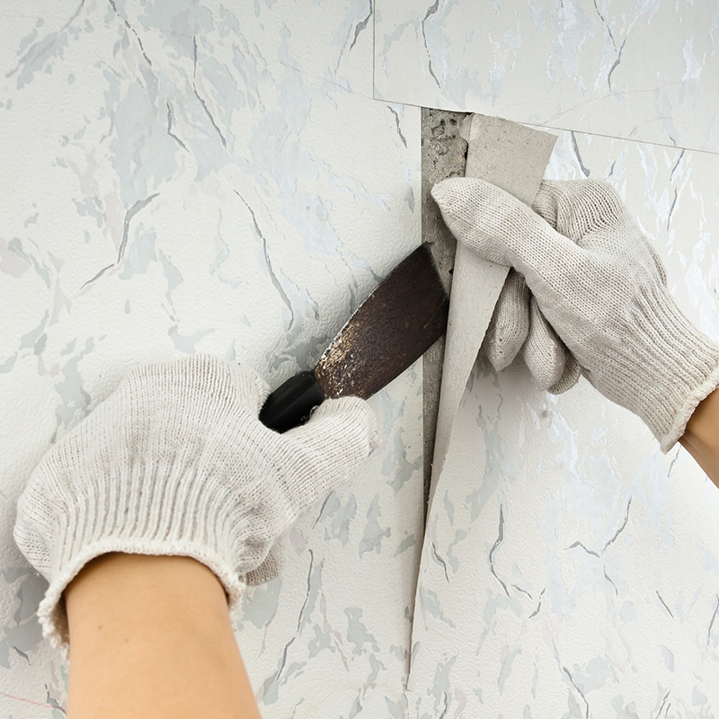 removing old wallpapers from wall with spatula
